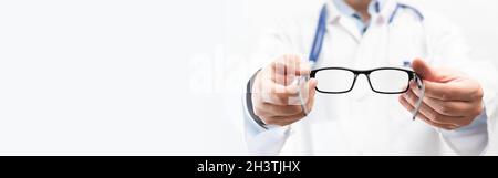 Medico oculare, oculista in clinica. L'optometro tiene gli occhiali da provare. Immagine spazio di copia banner Web Foto Stock