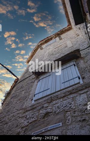 Inquadratura ad angolo basso di un edificio in pietra con un cartello che mostra la direzione verso un ufficio notarile in Croazia Foto Stock