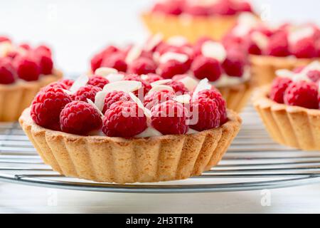 Mini tartine con crema pasticcera e lamponi. Foto Stock