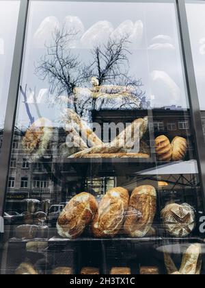 Pane in una finestra del ristorante. Riflesso degli alberi in una finestra di vetro. Foto Stock