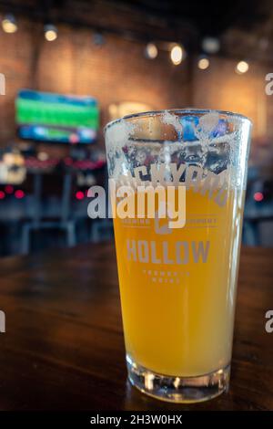 Portland, Maine - U.S.A. - 10-28-2021: Una birra fredda si siede su un tavolo a Brickyard Hollow a Portland nel Maine. Foto Stock