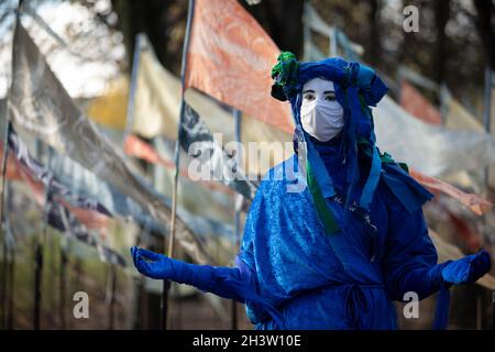 Glasgow, Regno Unito. Estinzione i ribelli blu della ribellione camminano attraverso le 500 bandiere della “Spiaggia dei sogni”, un’opera artistica di Ali Pretty di Kinetika, vicino alla 26a Conferenza Onu sul cambiamento climatico, nota come COP26, a Glasgow, Regno Unito, il 30 ottobre 2021. Photo credit: Jeremy Sutton-Hibbert/Alamy Live News. Foto Stock