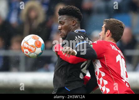 Bielefeld, Germania. 30 Ott 2021. Calcio: Bundesliga, Arminia Bielefeld - FSV Mainz 05, giorno di incontro 10 alla Schüco Arena. Bryan Lasme (l) di Bielefeld combatte per la palla con Stefan Bell (r) di Mainz. Credit: Friso Gentsch/dpa - NOTA IMPORTANTE: In conformità con le norme del DFL Deutsche Fußball Liga e/o del DFB Deutscher Fußball-Bund, è vietato utilizzare o utilizzare fotografie scattate nello stadio e/o del match sotto forma di immagini di sequenza e/o serie di foto video-simili./dpa/Alamy Live News Foto Stock