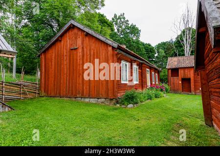 Idilliaci cottage rossi nella campagna svedese con prati verdi in una splendida giornata estiva Foto Stock