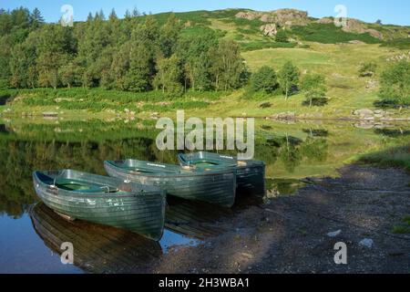 Barche a remi ormeggiate a Watendlath Tarn nel Lake District Cumbria Foto Stock
