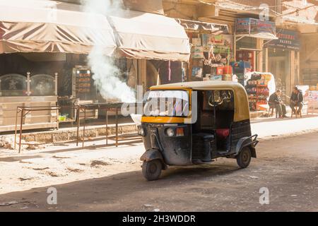 Alessandria d'Egitto - 18 dicembre 2018: Il risciò auto di Tuc tuc cavalca la strada di Alessandria, gente comune è sulla strada Foto Stock