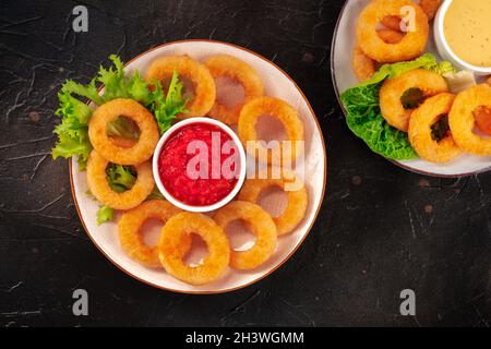 Anelli dei calamari. Anelli di calamari fritti profondi con varie salse, getto piatto sopra Foto Stock