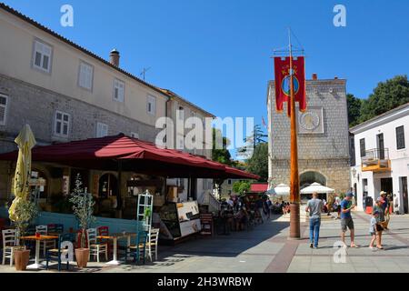 Krk, Croazia - 2 settembre 2021. I turisti e la gente del posto camminano nella storica piazza vela Placa nel centro storico medievale di Krk sull'isola di Krk Foto Stock