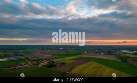 Tramonto con le nubi scure e drammatiche di tempesta di fondo che si dividono. La luce dal sole che tramonta la rende drammatica come colpisce Foto Stock