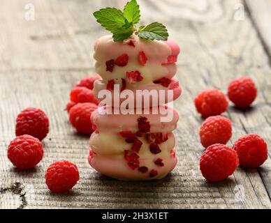 Una pila di macaron di lamponi e frutti di bosco cotti su un tavolo grigio Foto Stock