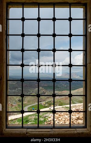 Una vista della città di Dogubeyazit, vista attraverso la finestra barred del palazzo di Ishak Pasha, nel distretto di Doğubeyazıt della città di Ağrı nella Turchia orientale. Foto Stock