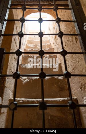 Scala di pietra vista attraverso la finestra barred del palazzo di Ishak Pasha nel distretto di Doğubeyazıt della città di Ağrı nella Turchia orientale. Foto Stock