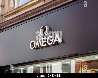 Logo e slogan sul negozio omega boutique sulla strada commerciale nel centro di leeds Foto Stock