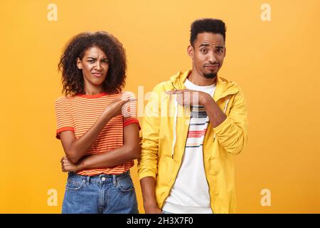 Amici che ottengono scioccati qualcuno ha pensato che stanno datando. Dispiaciuti mocking afroamericana femmina accigliarsi e gridering da Foto Stock