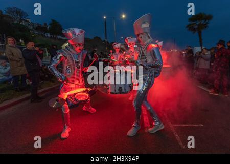 30 ottobre 2021. Southend on Sea, Regno Unito. Gli artisti di strada in costumi metallizzati dello spazio suonano la batteria in mezzo all'illuminazione rossa e agli effetti di fumo durante la sfilata di Halloween di Southend-on-Sea. La folla si riunisce lungo il lungomare per godersi lo spettacolo teatrale. Penelope Barritt/Alamy Live News Foto Stock