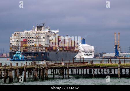 grande nave container nel porto di southampton ormeggia con un rimorchiatore a poppa. southampton attracca il rimorchiatore, la containerizzazione, la nave container southampton Foto Stock