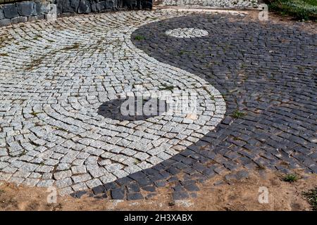 Simbolo Ying e yang realizzato con ciottoli. Foto Stock