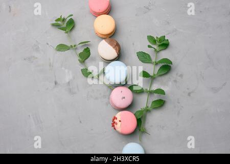 Macaron al forno con sapori diversi su sfondo di cemento grigio Foto Stock