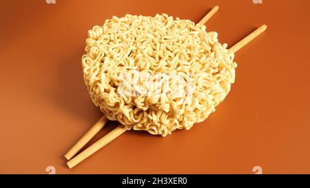 Tagliatelle secche crude con bacchette e spazio di copia. Cibo asiatico, minimalismo, pasta, per la preparazione di cui è eno Foto Stock