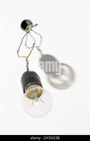 lampadina. illuminazione dell'ambiente. cavo con portalampada sul soffitto. preparazione di un posto per un lampadario. filo spesso grigio intrecciato e polveroso che fuoriesce Foto Stock