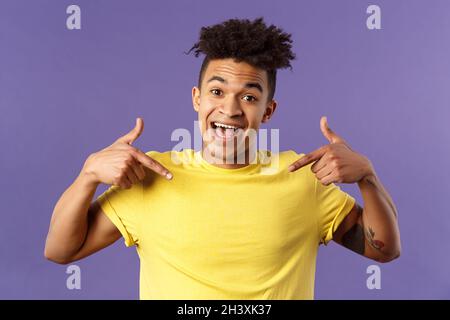 Sono quello di cui avete bisogno. Primo piano ritratto di carismatico, carino sorridente uomo astful, con orgoglio puntando a se stesso e parlando vinto acc Foto Stock