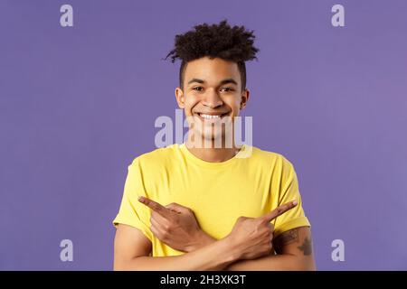 Primo piano ritratto di felice, buon uomo ispanico promozione di due prodotti, mostrando entrambi i modi buono, dare varianti, indicando Foto Stock