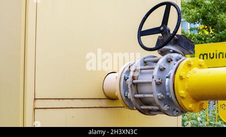 Tubo del gas giallo con rubinetto. Raccordi per tubazioni dell'olio nell'industria petrolifera e del gas. Impianto di trattamento di petrolio e gas con impianto di tubazioni Foto Stock