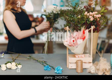 Fiorista donna fare bouquet in fiore boutique Foto Stock
