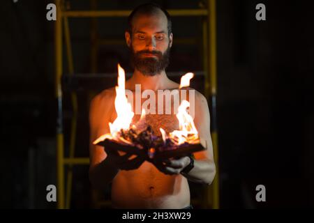 L'uomo tiene il libro bruciante nelle sue mani. Foto Stock