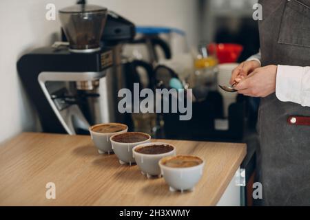 Tazza degustazione ragazza degustazione Degostation caffè prova di qualità. Tazza di caffè Foto Stock