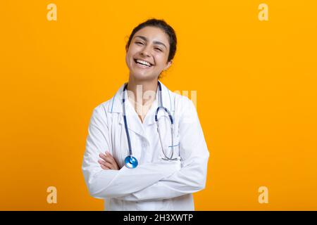 Ritratto di medico indiano donna in abito medico bianco isolato su sfondo giallo Foto Stock