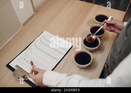 Tazza degustazione ragazza degustazione Degostation caffè prova di qualità. Tazza di caffè Foto Stock