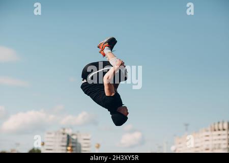 Ragazzo sportivo giovane facendo parkour alla strada della città. Foto Stock