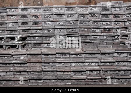 Parti in ferro del pezzo da lavorare per la posa di strutture metalliche di binari ferroviari in un cumulo in un impianto industriale. Foto Stock