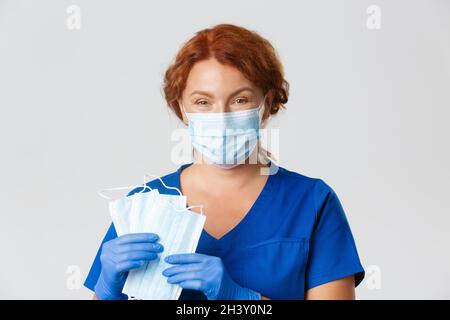 Operatori medici, covid-19 pandemia, concetto di coronavirus. Primo piano di sorridente infermiere, medico in guanti di gomma chiedere a. Foto Stock