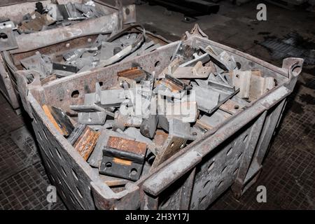 Parti in ferro del pezzo da lavorare per la posa di strutture metalliche di binari ferroviari in un cumulo in un impianto industriale. Foto Stock