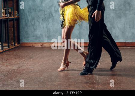 Sala da ballo samba. Giovane coppia in costumi gialli e neri danzanti. Foto Stock