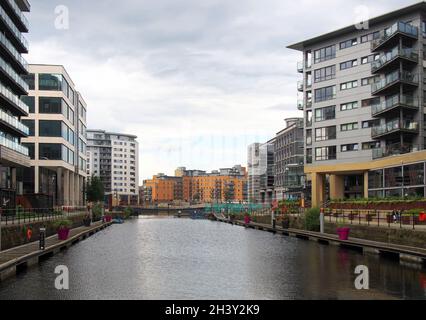 Vista lungo lo sviluppo del molo di leeds con edifici sul lungomare riflessi nell'acqua Foto Stock