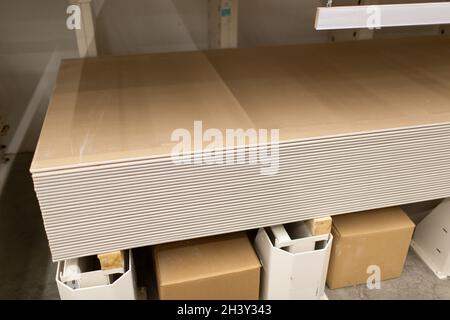 Pallet con cartongesso in lastre di cartongesso nel magazzino dell'edificio. Foto Stock