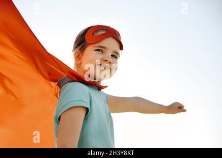 Ritratto di Superhero capretto su sfondo cielo blu Foto Stock