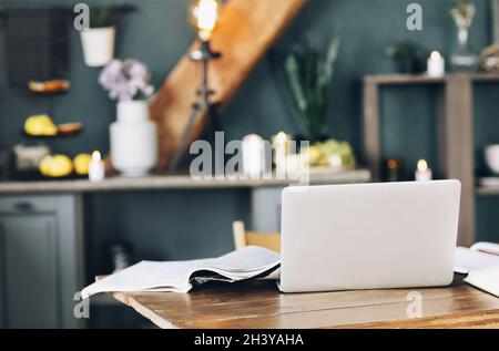 Apri un libro di testo con penna, laptop, pila di libri scoperti e tazza di caffè sul tavolo dell'ufficio a casa Foto Stock