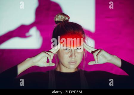 Giovane donna con mal di testa e fronte di colore rosso Foto Stock