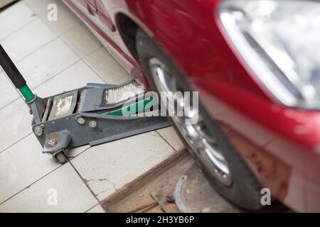 Martinetto idraulico per auto sollevare la nuova vettura per sostituire il  pneumatico. Cambio pneumatici stagionale o concetto astratto di assistenza  Foto stock - Alamy