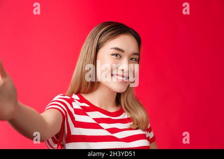 Primo piano tenero femminile sciocca studentessa ragazza scattare foto social media estendere braccio tenere fotocamera smartphone fare inclinazione selfie Foto Stock
