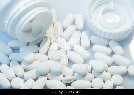 Helsinki / Finlandia - 31 OTTOBRE 2021: Primo piano di pillole bianche su sfondo bianco. Contenitore bianco per pillole sullo sfondo. Foto Stock