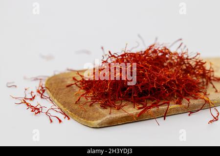 Zafferano orientali essiccati spezia su cucchiaio di legno. Foto Stock