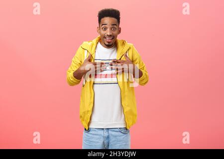 Mi vuoi dire. Ritratto di stupito stupito modello maschile afroamericano di buon aspetto con barba in giacca gialla alla moda puntata Foto Stock