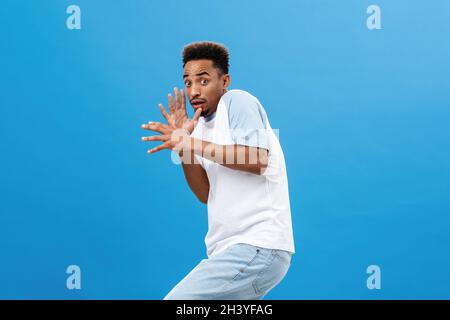 Mi hai paura fino alla morte. Scioccato intenso e spaventato divertente africano americano giovane studente maschile in t-shirt inclinando indietro ra Foto Stock