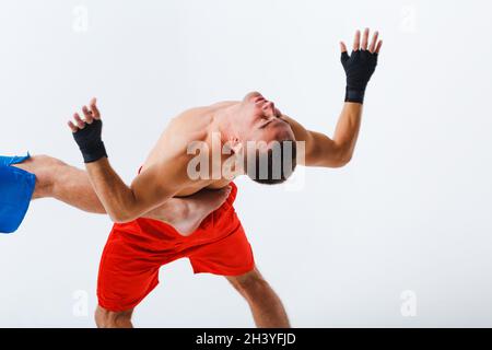 Due uomini boxer lotta muay thai kickboxing sfondo bianco Foto Stock