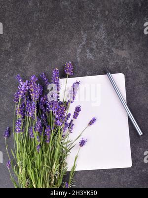 Vista dall'alto di blocco note vuoto aperto e bouquet di lavanda Foto Stock